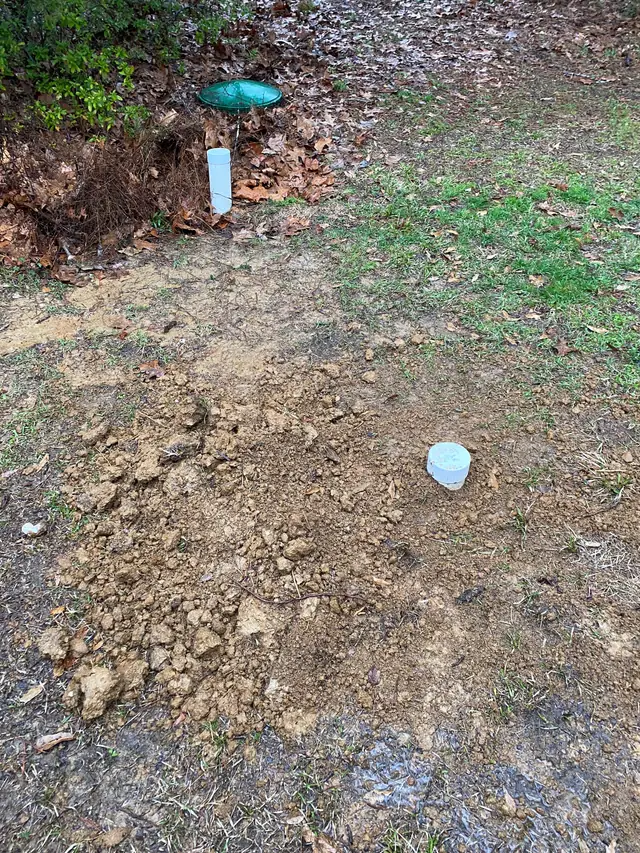 Completed riser installation with green cap on septic tank